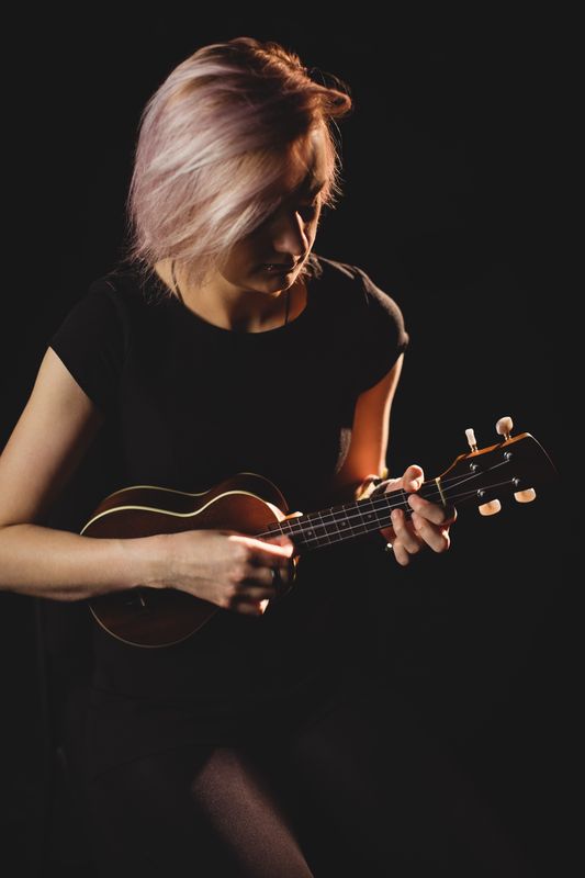Woman playing a guitar in music school
