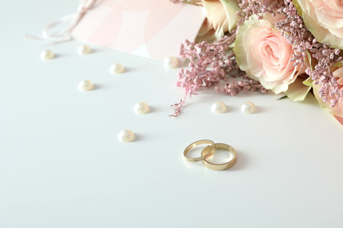Concept of wedding accessories with wedding rings on white backg